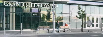 The glass street entrance of Grand Villa Casino in the ICE District, with the casino name above the doors, photographed in 2018